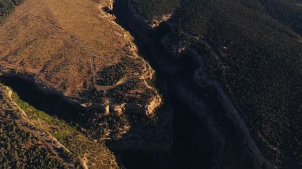 木々に覆われた日光に照らされた崖のドローン撮影と古代プエブロ寺院の遺跡 ヴェルデ国立公園 コロラド州 アメリカ — ストック動画