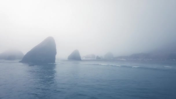 Dron girato oceano calmo vicino a una riva rocciosa nella nebbia pesante Ariyas Beach, Oregon, Stati Uniti d'America — Video Stock