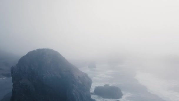 Yoğun siste okyanustan çıkan siyah bir uçurumun havadan görünüşü Ariyas Sahili, Oregon, Usa — Stok video