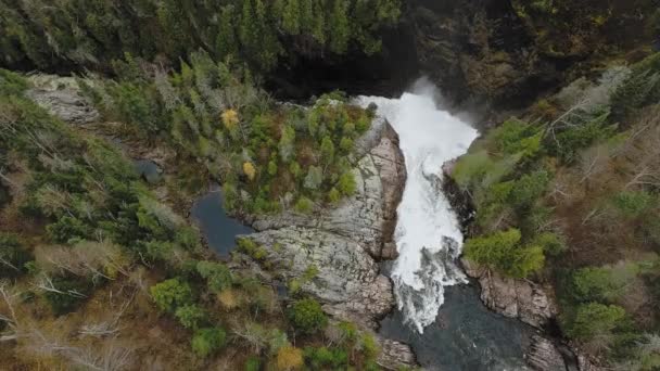 A drone camera approaches a waterfall between the shores with an autumn forest Aguasabon Falls, Ontario, Canada — Stock Video