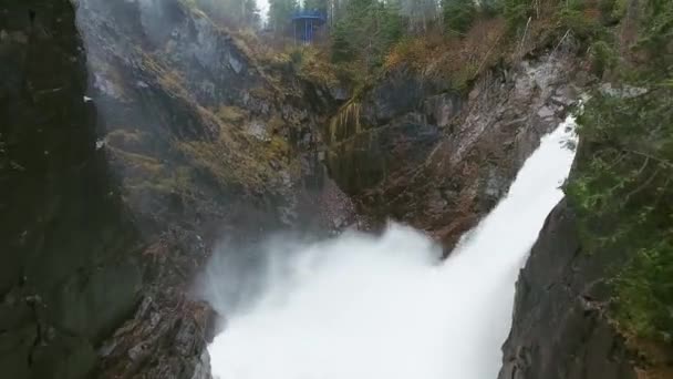 Tiro aéreo de uma cachoeira tempestuosa batendo pedras em um desfiladeiro com uma floresta densa Aguasabon Falls, Ontário, Canadá — Vídeo de Stock