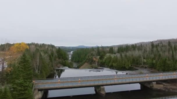 Повітряний вогонь по мосту над дзеркальною річкою з осіннім лісом Каміністікія (Канада). — стокове відео
