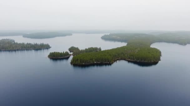 Drone närmar sig små öar med tät skog i en sjö med dimmig horisont Willard Lake, Ontario, Kanada — Stockvideo