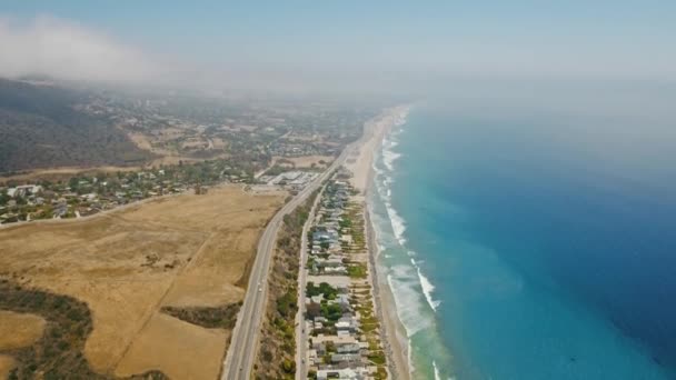 Vue aérienne de la route, des voitures, du champ, de la plage, des maisons, du rivage, des vagues, de l'océan bleu et d'un morceau de canyon Malibu, Californie, USA — Video