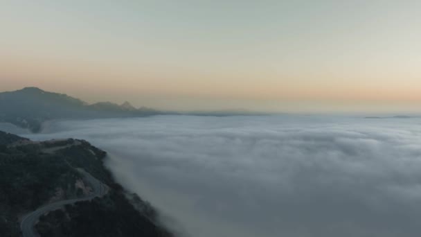 Luchtfoto vliegen over een weelderige groene berg met een bocht van de weg onder de wolk Malibu Canyon, Calabasas, California, USA — Stockvideo