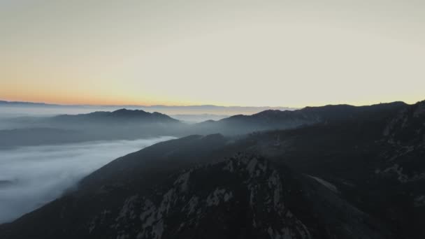 Vista aérea de uma paisagem montanhosa com uma floresta densa coberta por um denso véu de nevoeiro ao nascer do sol Malibu Canyon, Calabasas, Califórnia, EUA — Vídeo de Stock