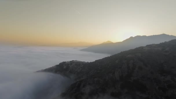 Drohnen-Kamera filmt Gipfel des Canyons, dicke Wolken und eine Spur am Himmel aus dem Flugzeug Malibu Canyon, Calabasas, Kalifornien, USA — Stockvideo