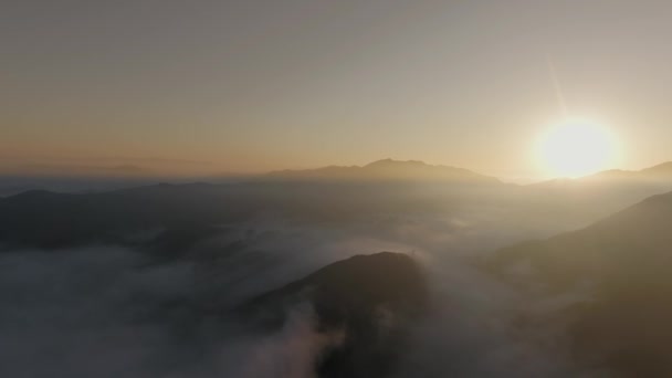 Vista aérea del amanecer a través de las nubes sobre las cimas del cañón Malibu Canyon, Calabasas, California, EE.UU. — Vídeo de stock