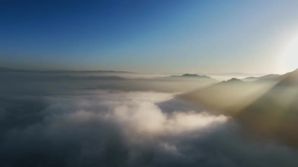 Flygfoto över solljus nära böljande moln och bergstoppar Malibu Canyon, Monte Nido, Kalifornien, USA — Stockvideo