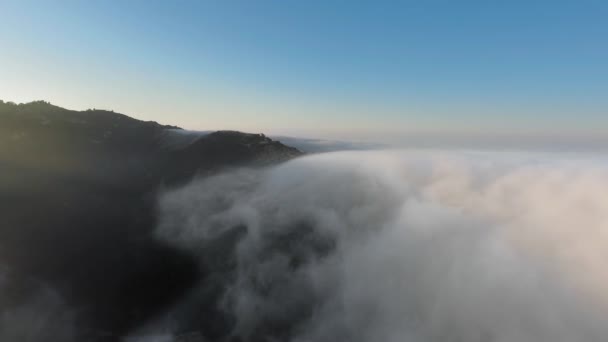 Vista aérea de nuvens espessas nebulosas sobre o cânion ao nascer do sol Malibu Canyon, Monte Nido, Califórnia, EUA — Vídeo de Stock