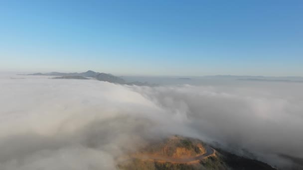 Vista aérea de un paisaje montañoso en densas nubes, curva visible de la carretera Malibu Canyon, Monte Nido, California, EE.UU. — Vídeo de stock