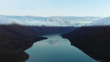 Alaska, Eklutna Gölü 'ndeki dağların ve karla kaplı zirvelerin yansıması olan sakin bir gölün hava görüntüleri.