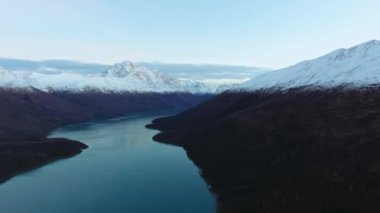 İnsansız hava aracı, ABD 'nin Alaska eyaletindeki Eklutna Gölü' ndeki karlı dağlar arasında donmuş bir gölün kıyılarını vuruyor.