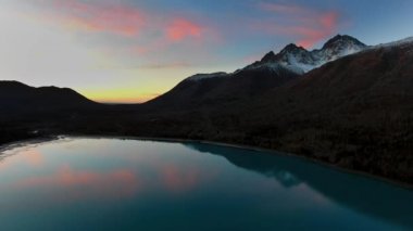 Gün batımında eklutna Gölü, Alaska, ABD 'de inanılmaz pembe bulutlarla mavi bir gölün hava görüntüsü.