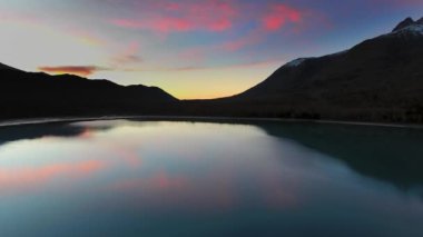 Drone, ABD 'nin Alaska eyaletindeki Eklutna Gölü' nde ormanlık ve dağlı bir gölde macenta günbatımının yansımasını yakalar.