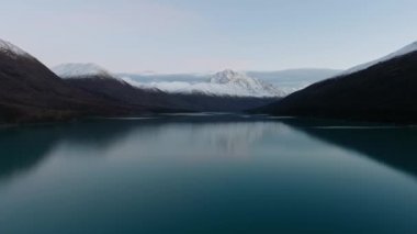 Drone, ABD 'nin Alaska eyaletindeki Eklutna Gölü' nde akşam saatlerinde karla kaplı dağlar arasında donmuş bir göl vuruyor.