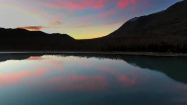 İnsansız hava aracı, ABD 'nin Alaska eyaletindeki Eklutna Gölü' nde gün batımında bir dağın yakınındaki bir gölde mor bulutların yansımasını yakalıyor.