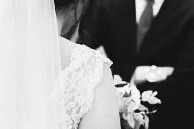 Düğün gününde bir gelinin omzunun siyah beyaz fotoğrafı.