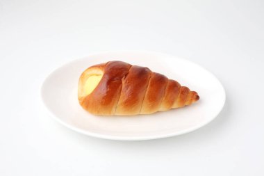 Beyaz arka planda izole edilmiş tabakta kremalı cornet rulo ekmek