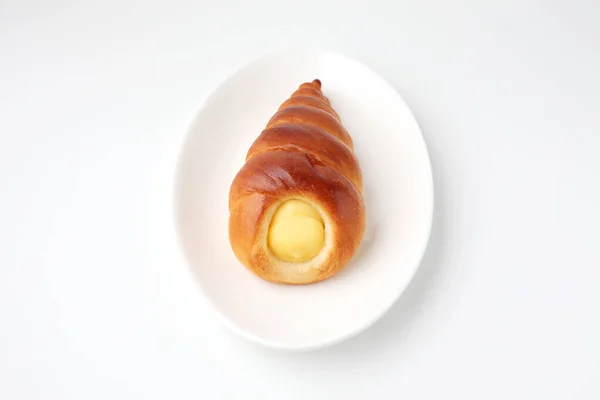 Crema corneta rollo pan en plato aislado sobre fondo blanco — Foto de Stock