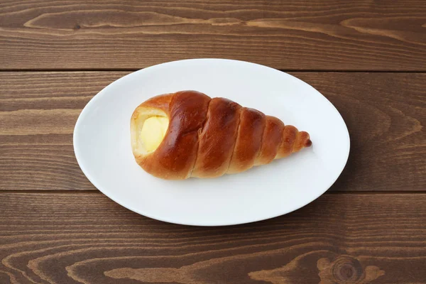 Pão de rolo de corneto creme na placa isolada na mesa — Fotografia de Stock