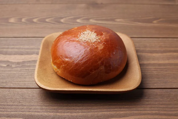 Anpan round bread with azuki red beans paste isolated on plate on wooden table — Stok fotoğraf