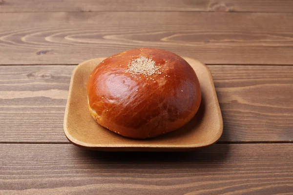 Anpan round bread with azuki red beans paste isolated on plate on wooden table — Stok fotoğraf