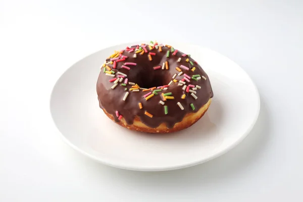 Пончик с шоколадной глазурью на белом фоне — стоковое фото