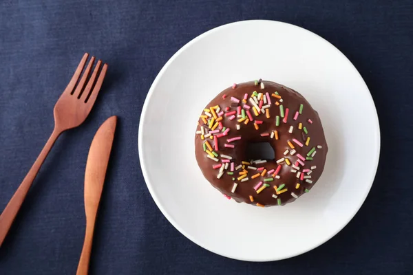 Rosquilla esmerilada de chocolate en el plato en la mesa — Foto de Stock