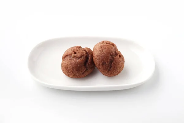 Шоколадные шарики на тарелке на белом фоне — стоковое фото