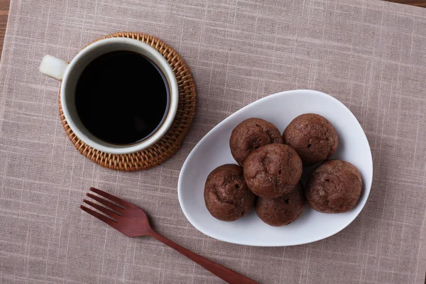 Schokoladencreme auf Teller mit heißem Kaffee isoliert auf Holztisch — Stockfoto