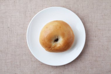 plain bagel bread on plate isolated on table cloth