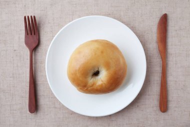 plain bagel bread on plate isolated on table cloth