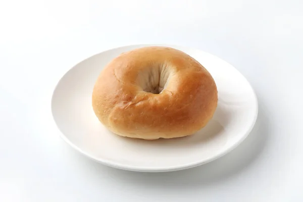 Obyčejný Bagel chleba na desce izolované na bílém pozadí — Stock fotografie