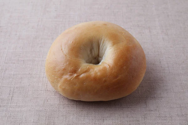 Plain bagel bread isolated on table cloth — 图库照片