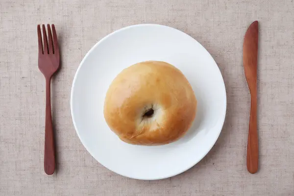 Pão de bagel simples na placa isolado na toalha de mesa — Fotografia de Stock