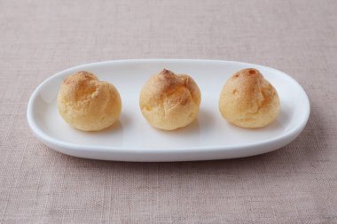 cream puffs on plate isolated on table cloth