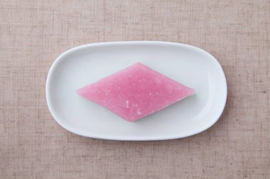 Onun himochi elmas şekilli pirinç keki Japon geleneksel şekerlemesi masa örtüsünde izole edilmiş.