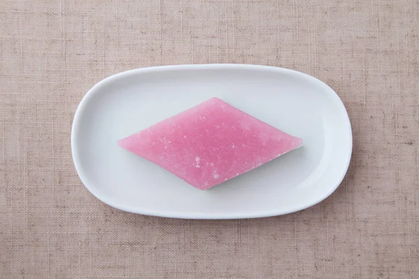 Bolo de arroz tricolor em forma de diamante hishimochi Confeitaria tradicional japonesa na placa isolada na toalha de mesa — Fotografia de Stock