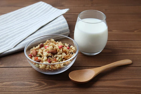 Cereal de granola en tazón con leche aislada en mesa de madera — Foto de Stock