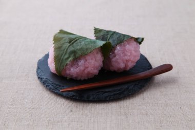 Sakura mochi pirinç keki Japon pastası masa örtüsünün üzerinde tabakta.