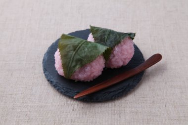 Sakura mochi pirinç keki Japon pastası masa örtüsünün üzerinde tabakta.