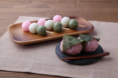 Sakura mochi ve dango 3 renkli pirinç keki masa örtüsü üzerinde.