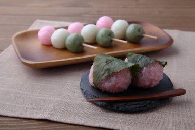 Sakura mochi ve dango 3 renkli pirinç keki masa örtüsü üzerinde.