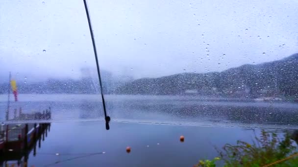 Punto di vista POV seduto da solo al lago nel giorno di pioggia. Ombrello chiaro e gocce di pioggia che gocciolano. Astratto triste e solo — Video Stock