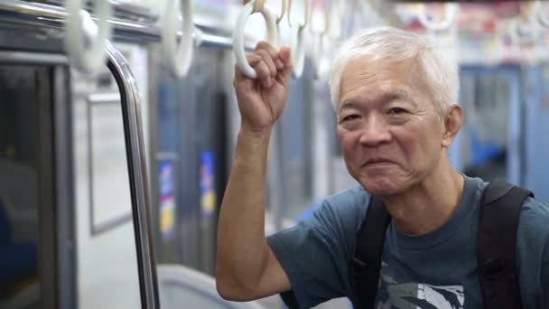 Asiatico senior utilizzando i mezzi pubblici per fare pensionamento viaggio di viaggio — Video Stock