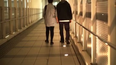 Asya üst düzey emekli çift tutuşup kapak patika boyunca Tren İstasyonu'ndan kat mülkiyeti için yürüyüş