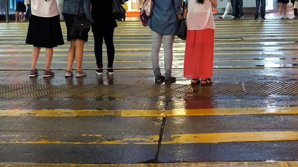 Asiatiques traversent rue humide avec néon réflexion de la lumière — Photo