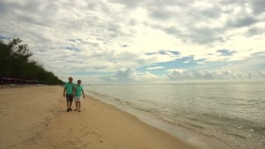 Asya kıdemli iki mutlu Sahilde yürüyüş. Emekli yaşam tarzı mali sorun değil iyi planı