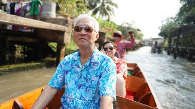 Asian elderly couple having fun retirment trip around the world clipart